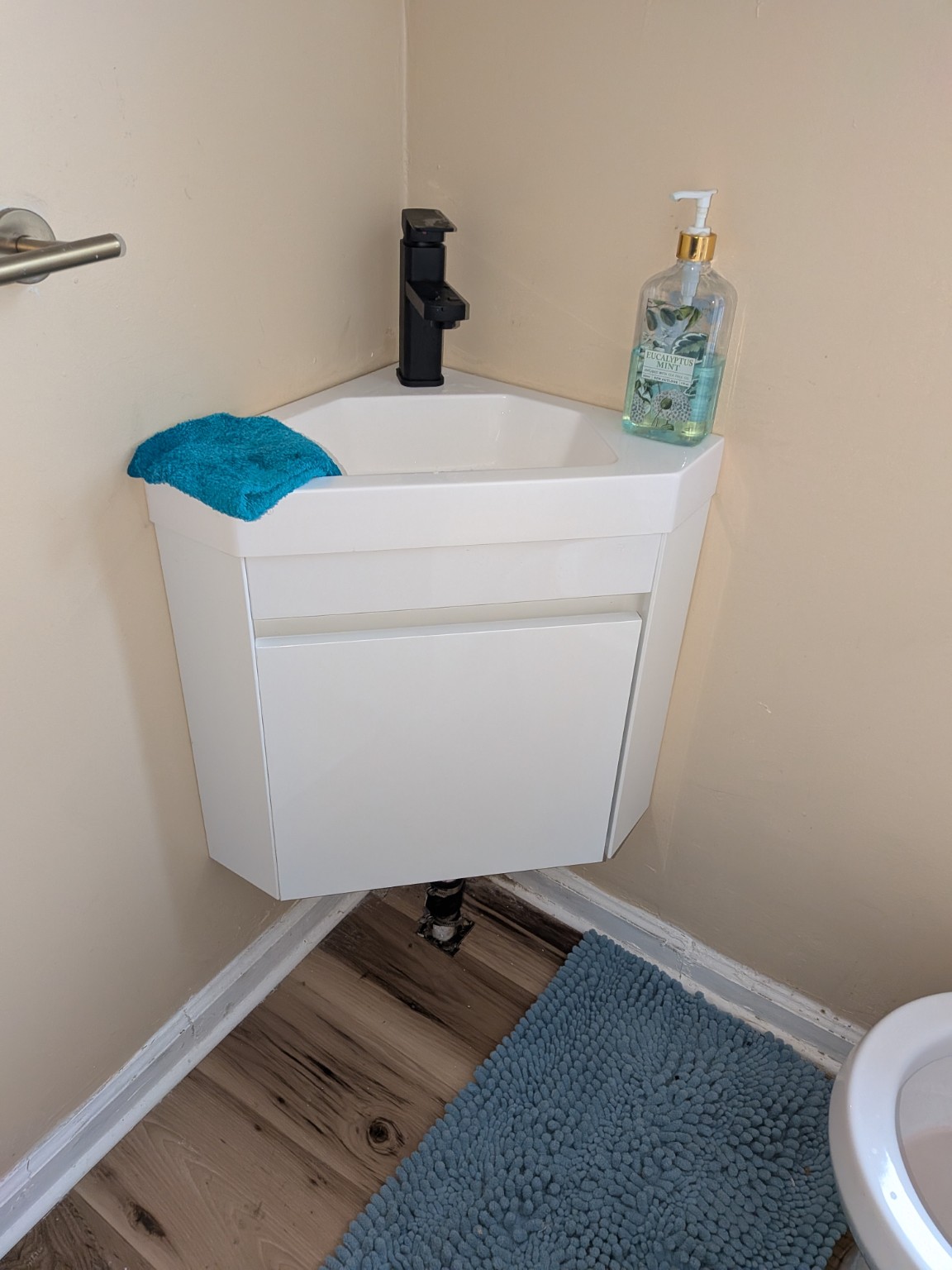 Wall-mounted bathroom vanity and black faucet installed by AHVEE