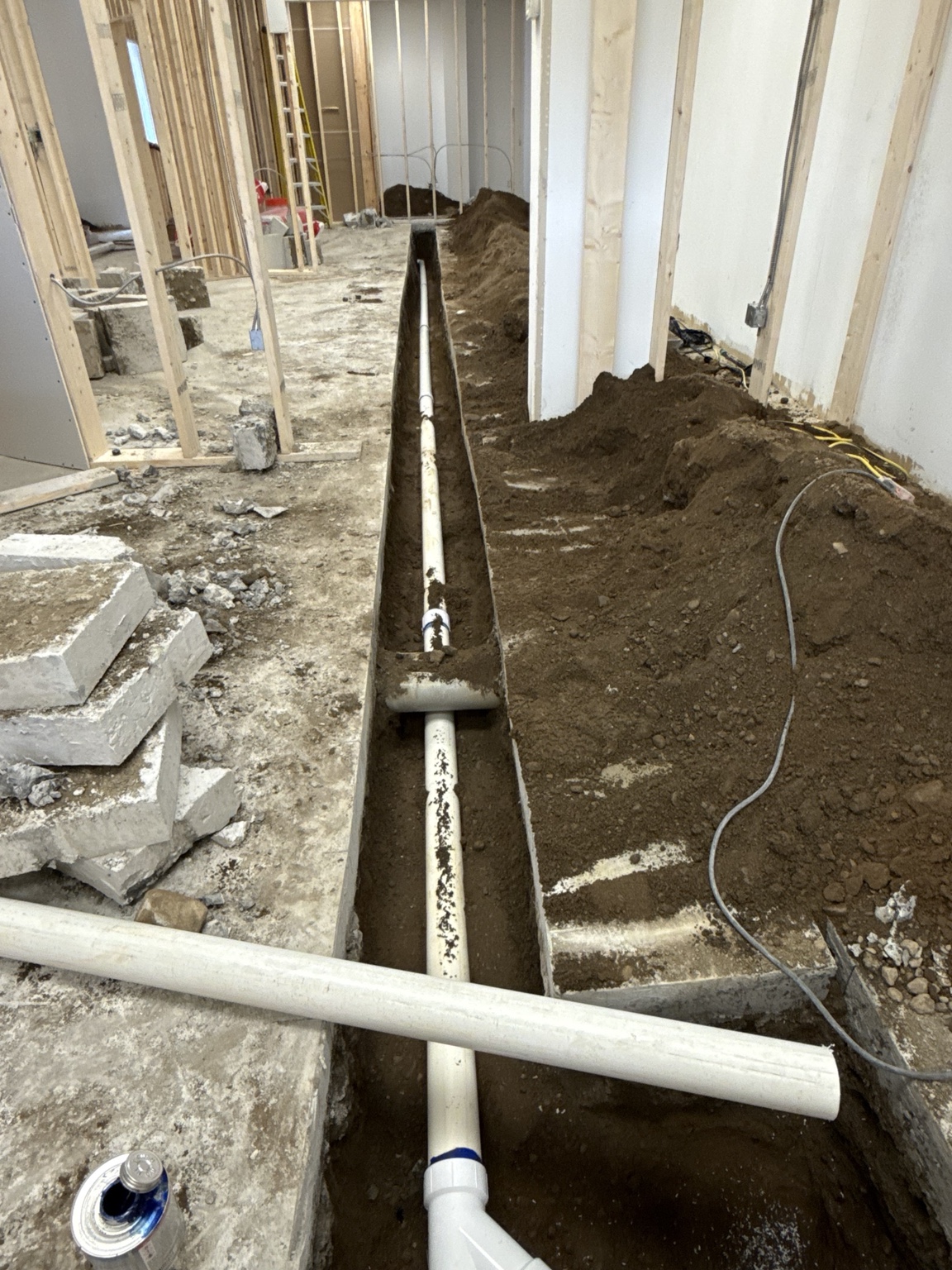 Underground PVC drain piping installed in a long open trench